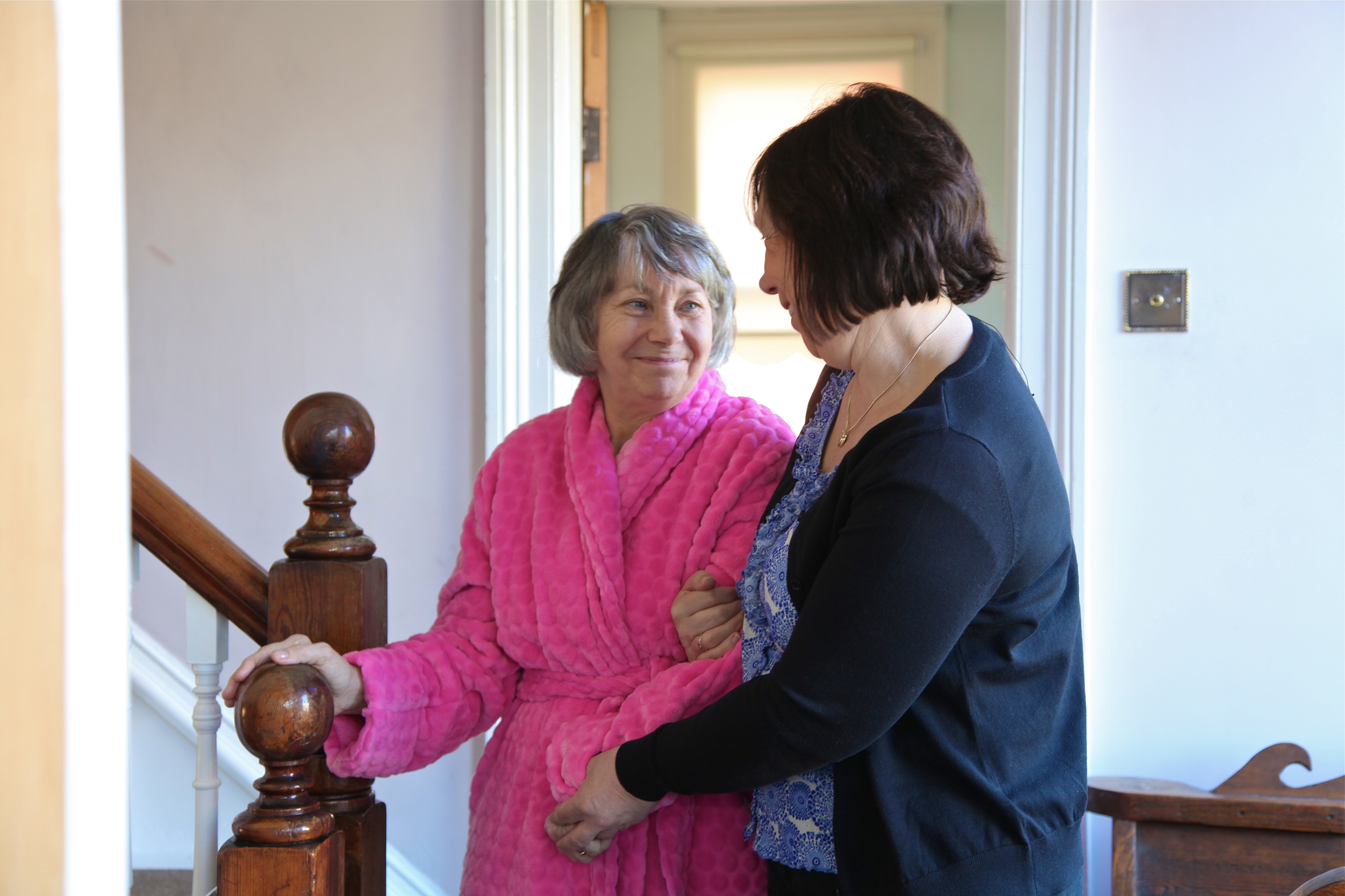 Homecare care giver assisting client around their home.