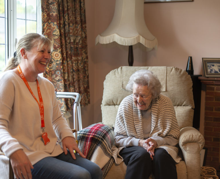 Carer and client sitting indoors
