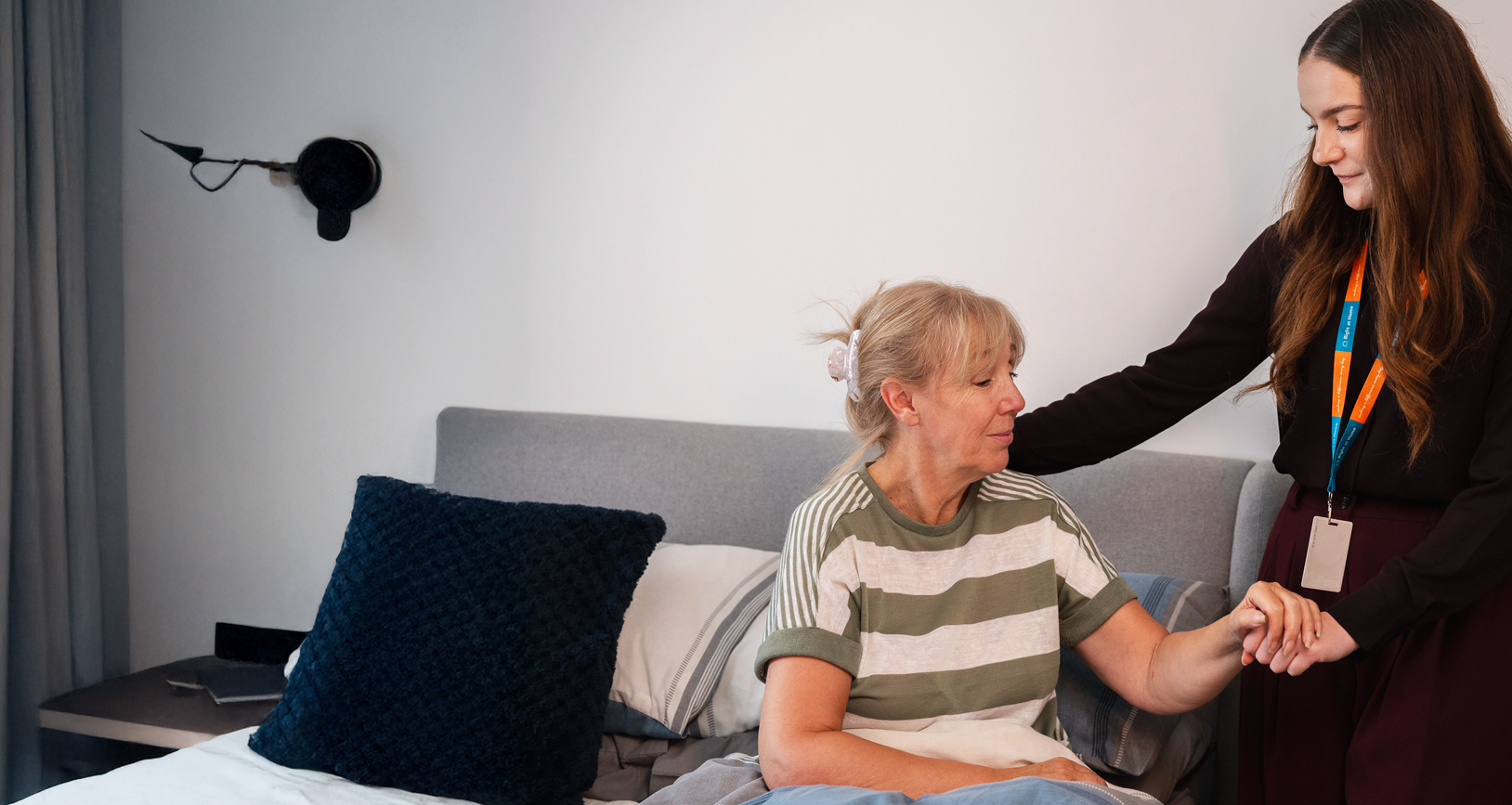 A carer supporting a client out of bed as part of their complex care at home